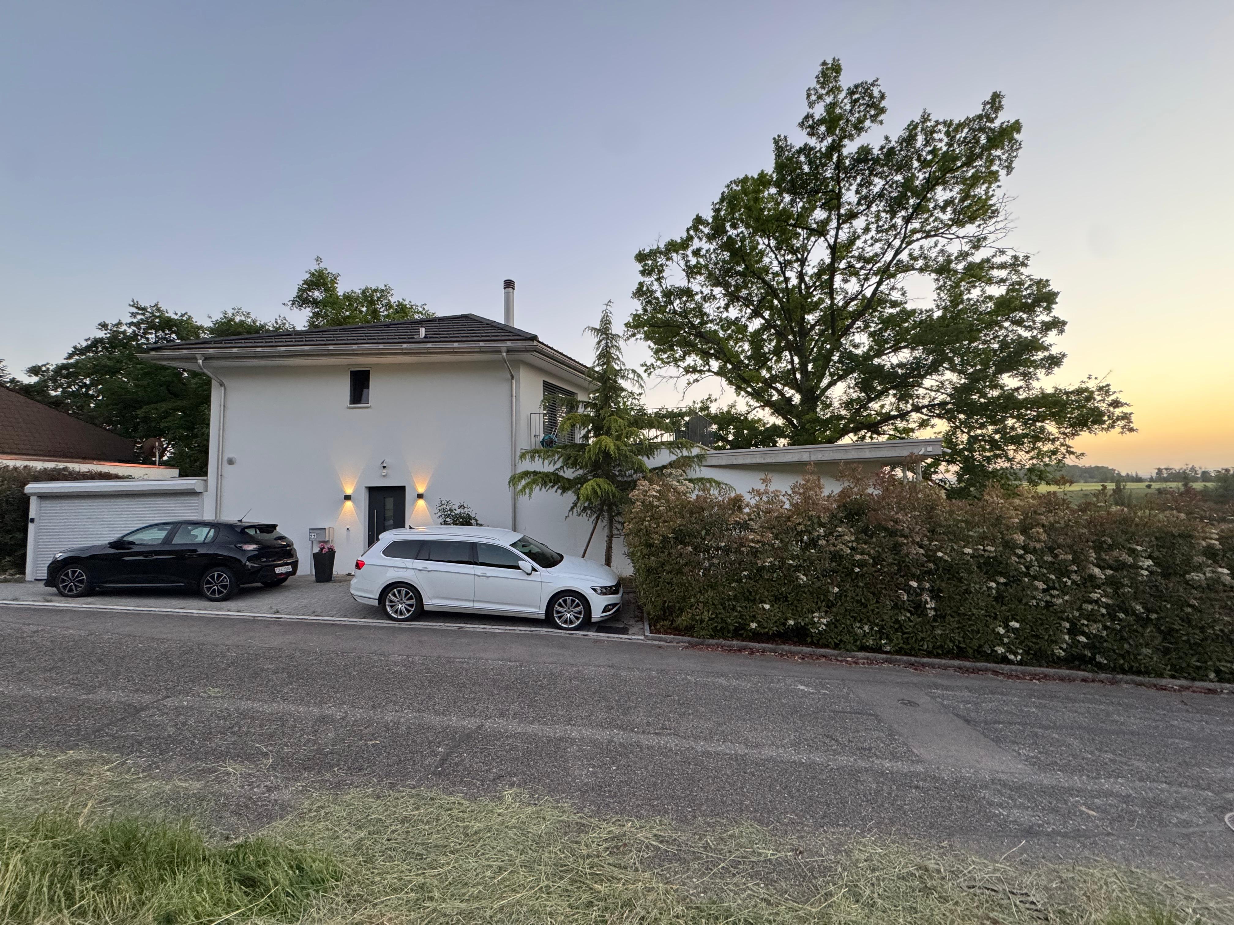 Villa 77 from the street at dusk with parking, furnished private house near PSI and Zürich